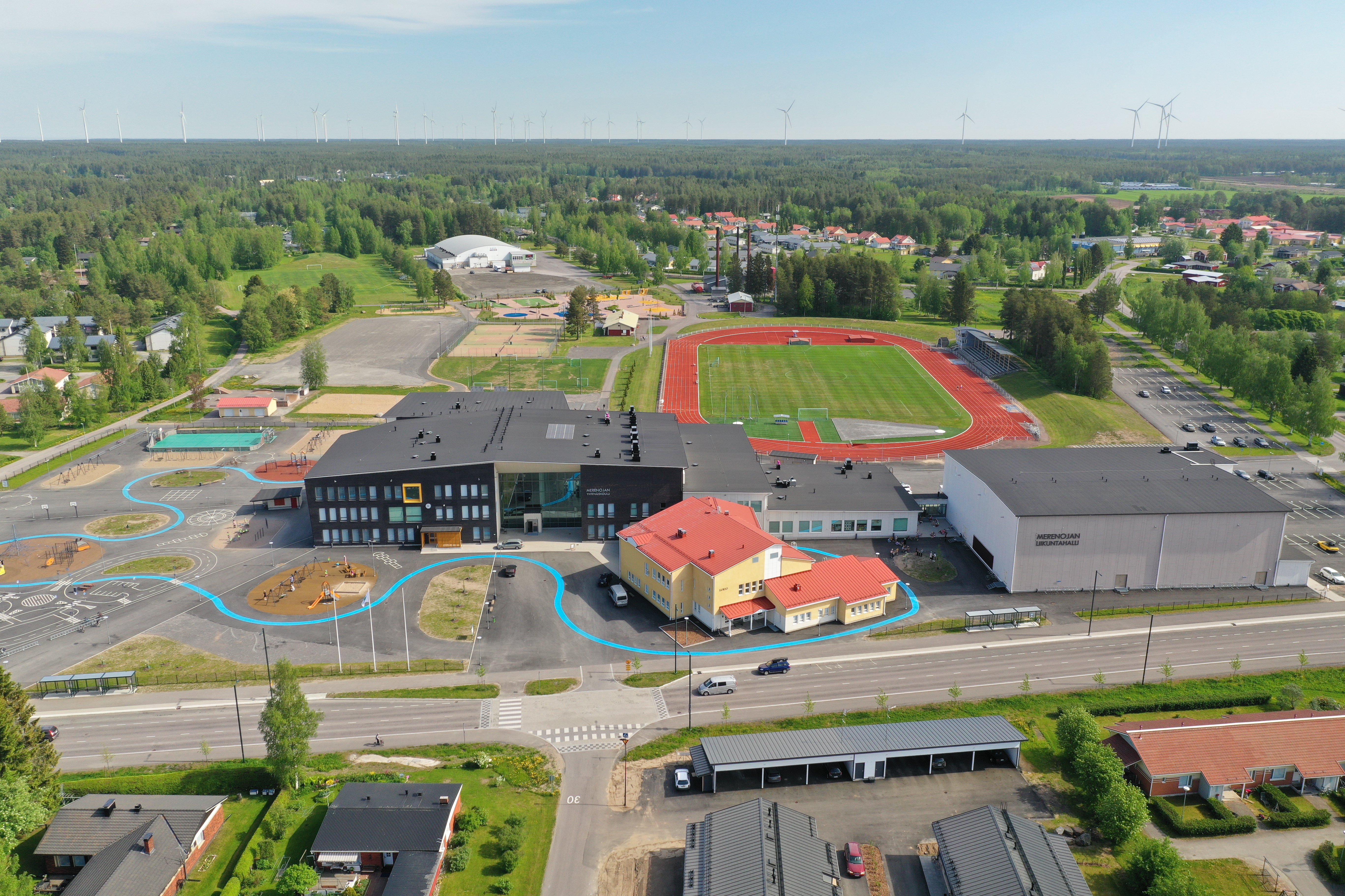 Koulurakennuksia ja taustalla urheilukenttä ja liikuntapaikkoja.