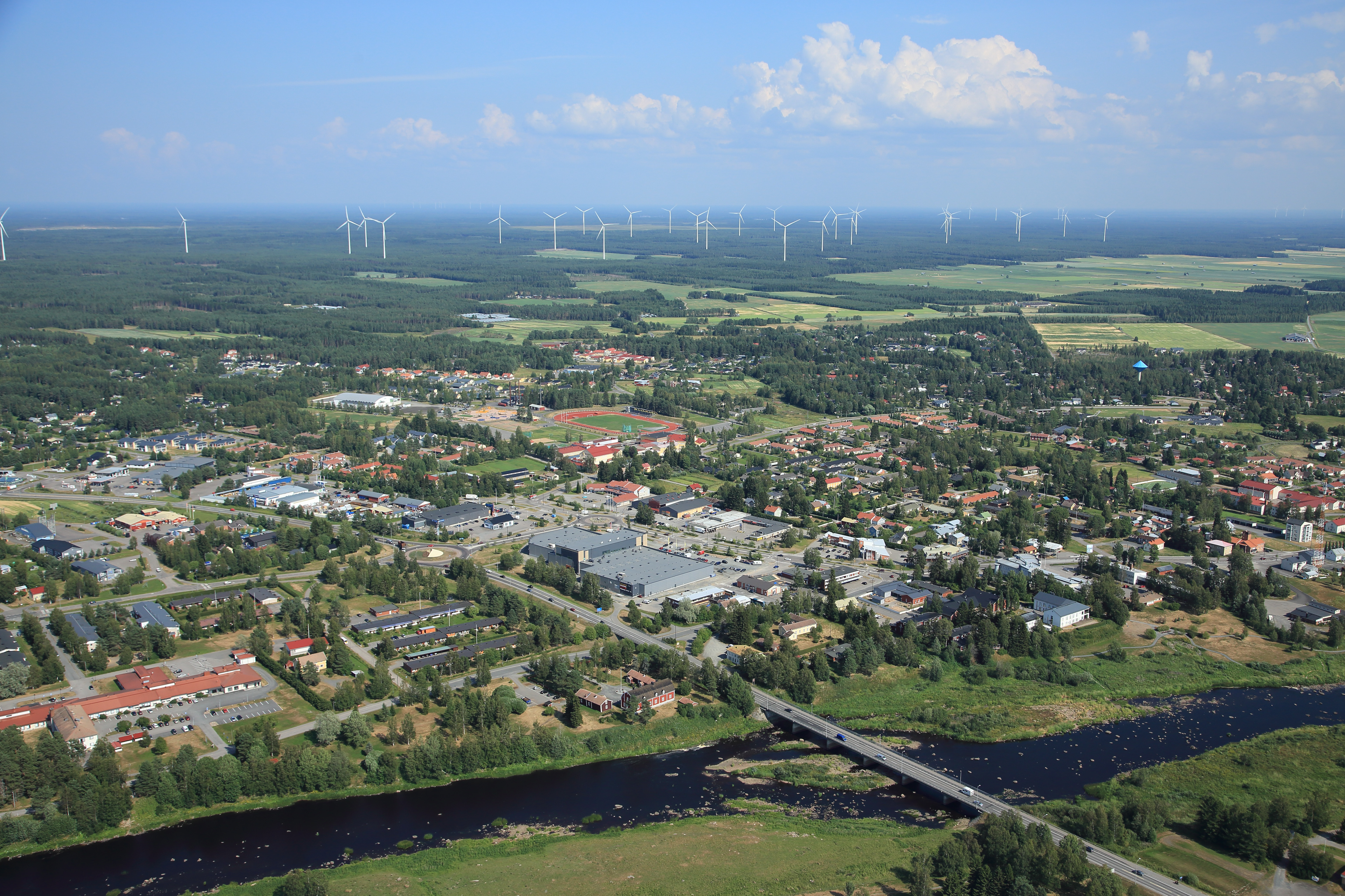 Kesäinen kuva Kalajoen keskustasta, joki, rakennuksia ja tuulimyllyjä