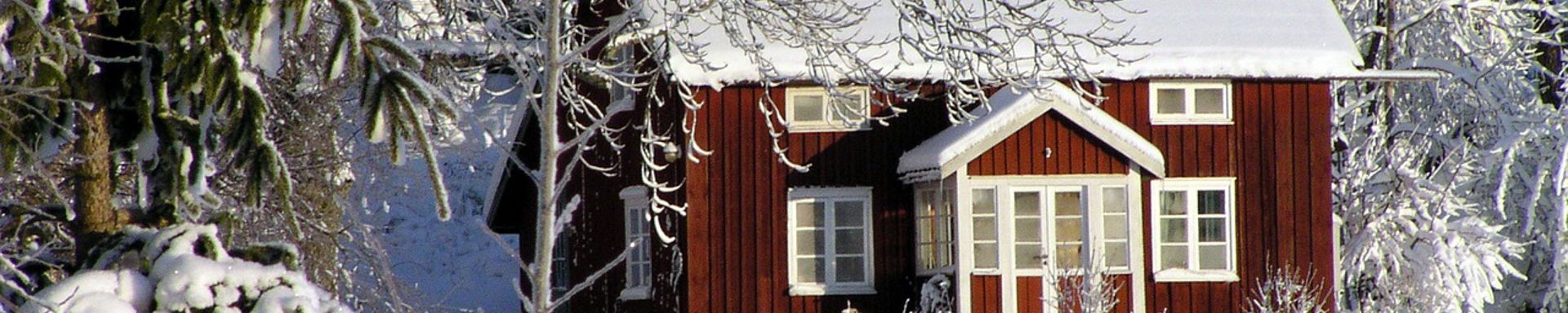 Kuvassa punainen rakennus lumisessa maisemassa.