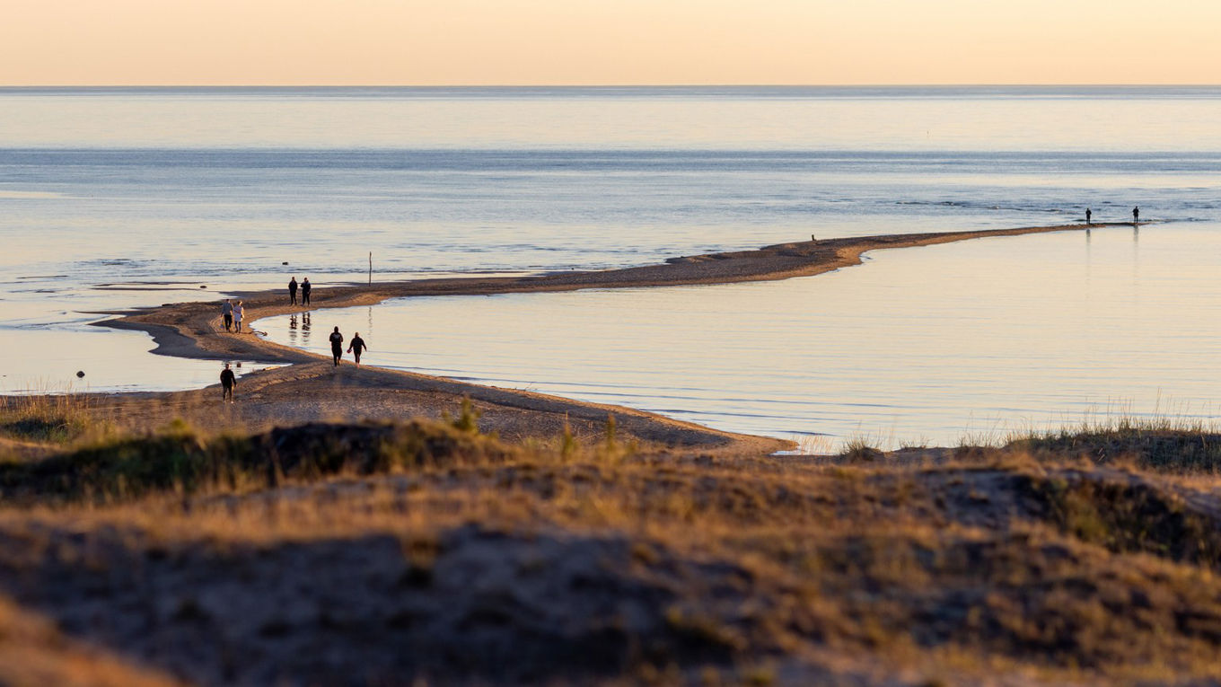 Ihmisiä kävelee rannalla ja säikällä Kalajoen Hiekkasärkillä.