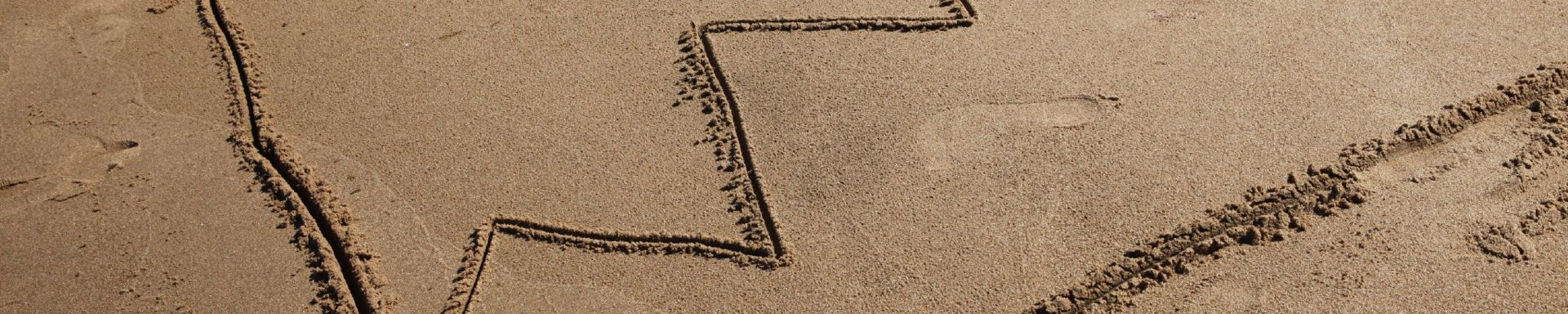 Nouseva  käyrä piirrettynä hiekkaan.