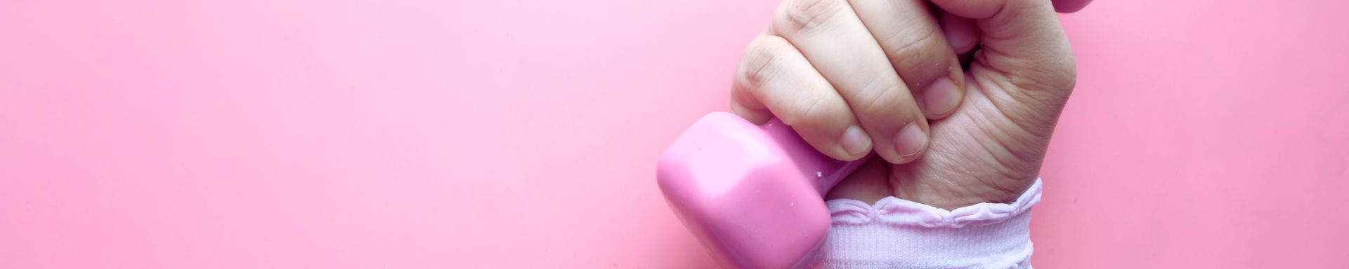 Käsi pitää vaaleanpunaista käsipainoa.