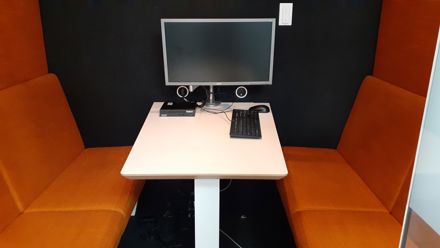 Pöytä, jonka molemmin puolin selkänojalliset penkit. Tietokone, näppäimistö ja hiiri.