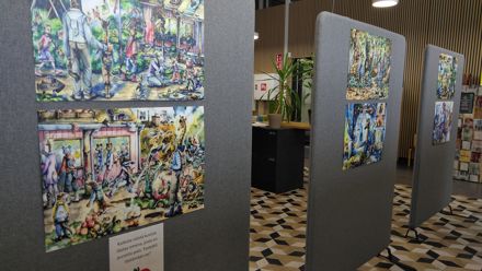 Kolme harmaata sermiä, joihin on kiinnitetty värikkäitä piirroksia.