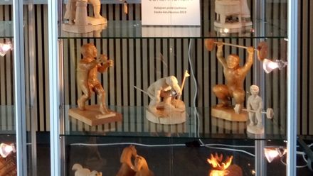 Lasinen vitriini, jossa on sisällä puuveistoksia.