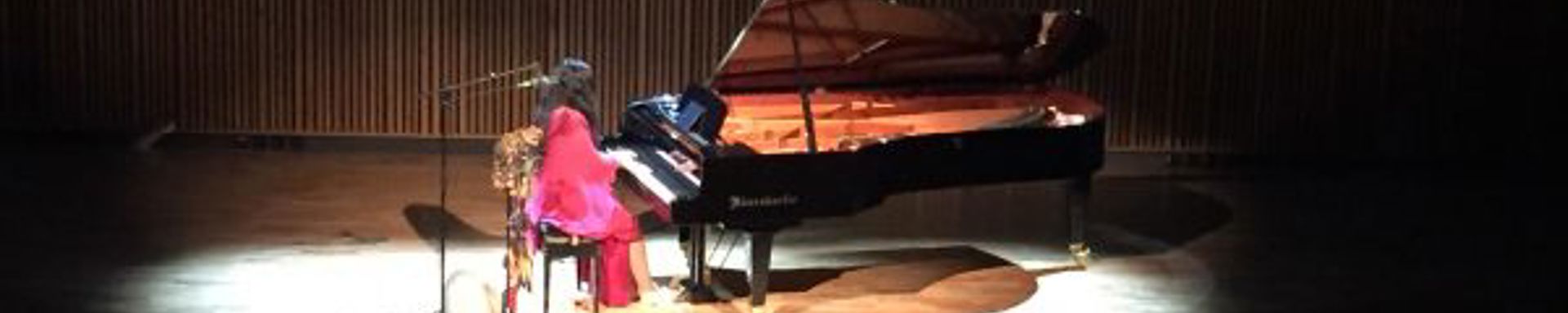 Pianisti spottivalossa pianon ääressä.