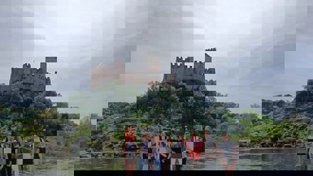 students in front of a castle over a river