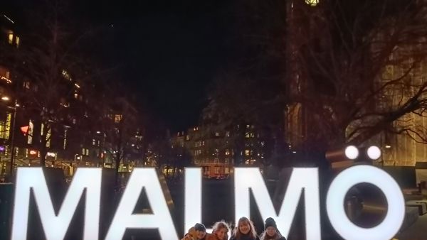 students at night in front of the signs Malmö