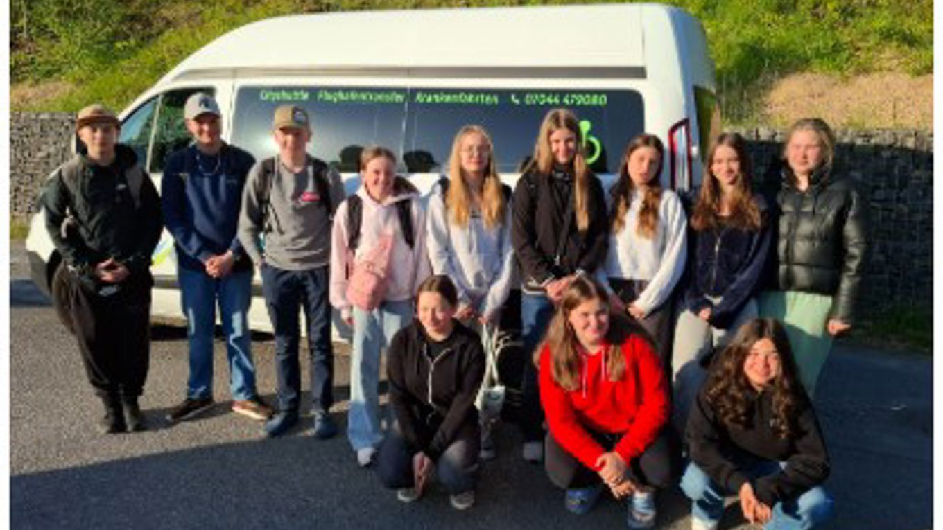 students in front of a car