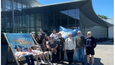 people on a big seat in front of a building