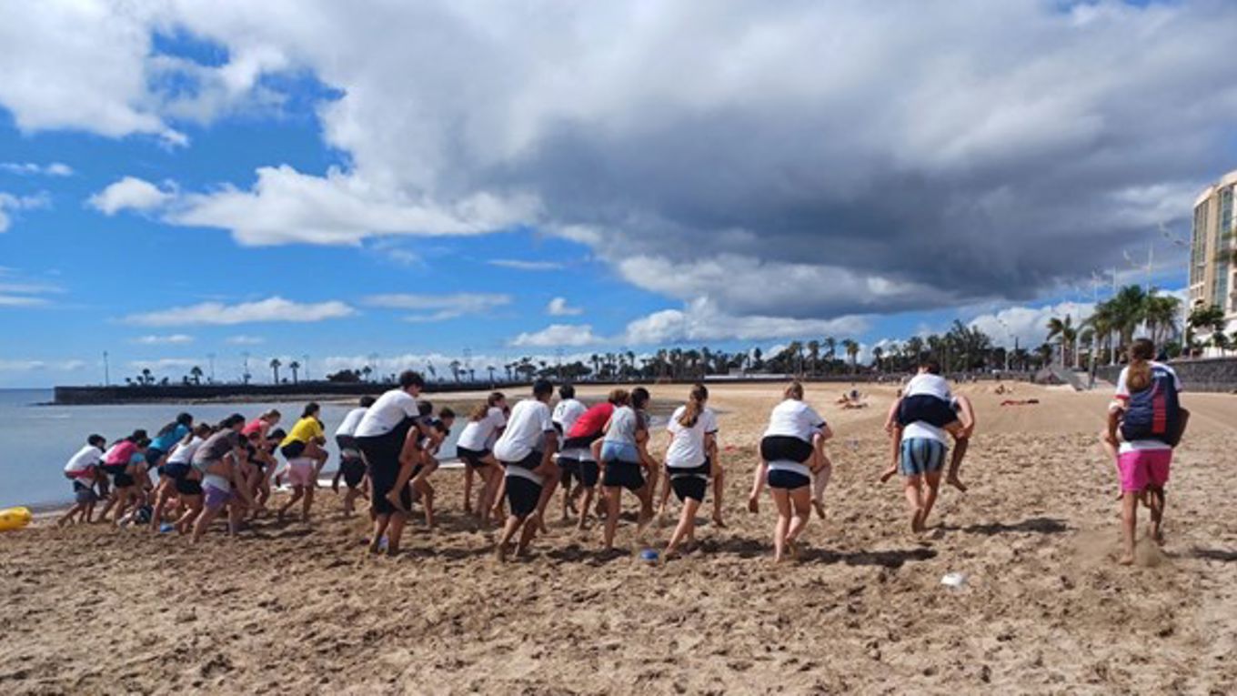 Young people at the beach piggyback riding