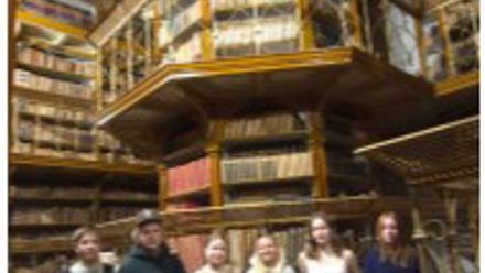 students in front of a tower of glass