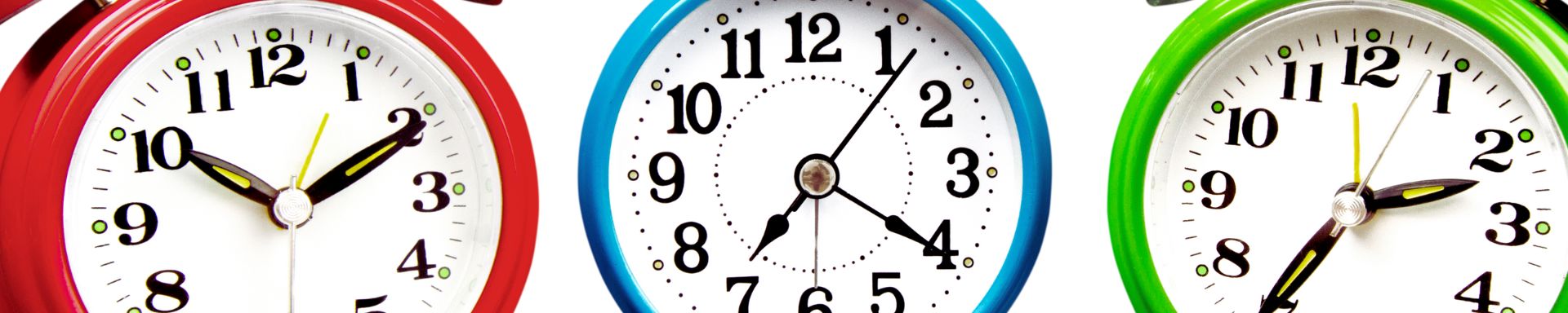 Kolme eriväristä vanhanajan herätyskelloa.